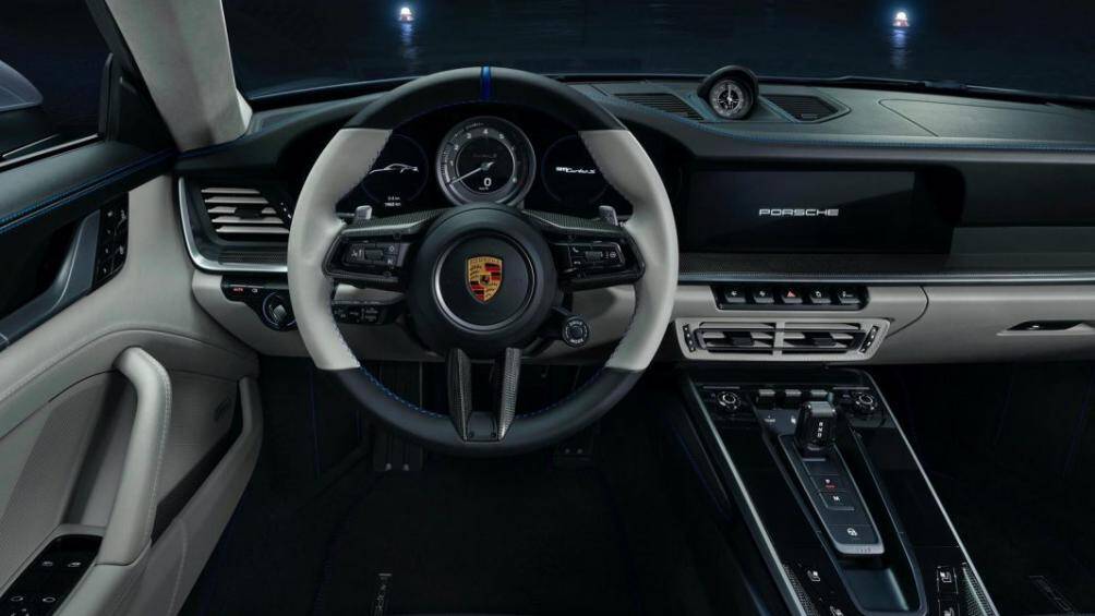 Khoang lái của 911 Turbo S "Duet" được bọc da với hai tông màu chủ đạo là đen và xám tro, đi cùng chỉ khâu tương phản màu xanh nổi bật