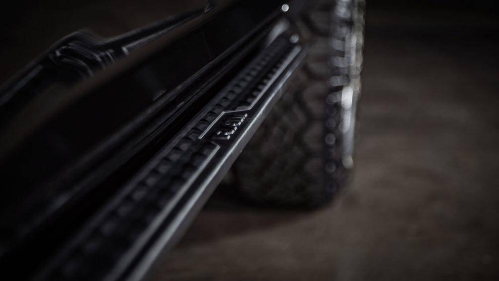 Những chi tiết như ốp viền cửa, kính, đèn đều được sơn màu đen bóng, hòa hợp cùng các trang bị như bệ bước chân, ốp gầm tạo cho xe vẻ ngoài cứng cáp