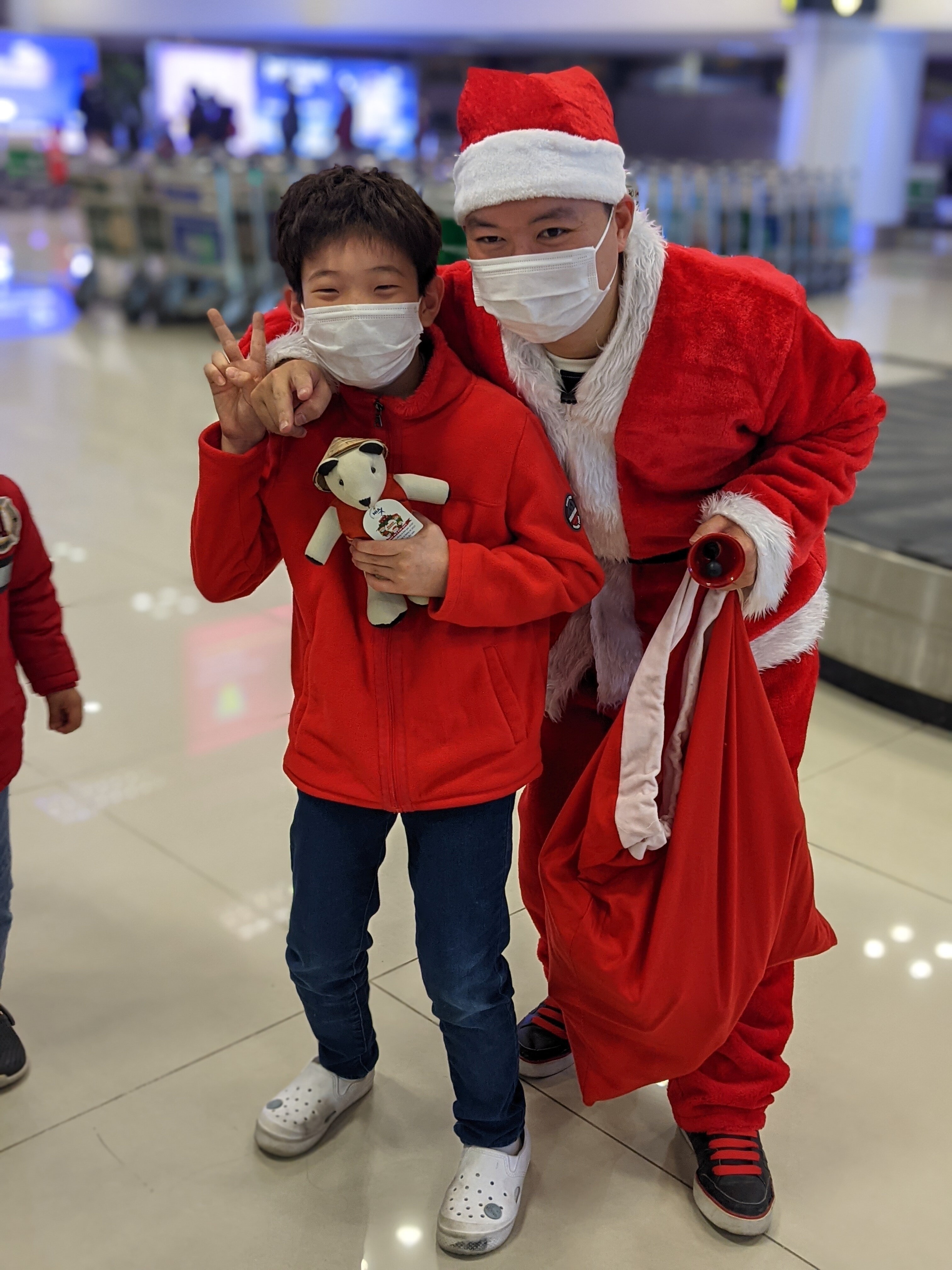 Một bé trai hào hứng tạo dáng với Santas NIA