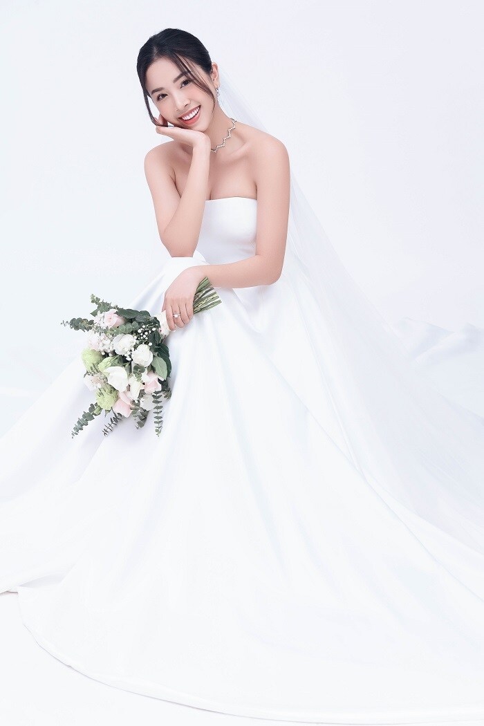 Thúy An lựa chọn chiếc đầm cưới trắng tinh khôi cho ngày trọng đại. Kiểu dáng cúp ngực cùng thân váy xòe, kết hợp layout tóc nhẹ nhàng giúp tôn lên nét dịu dàng, nữ tính,