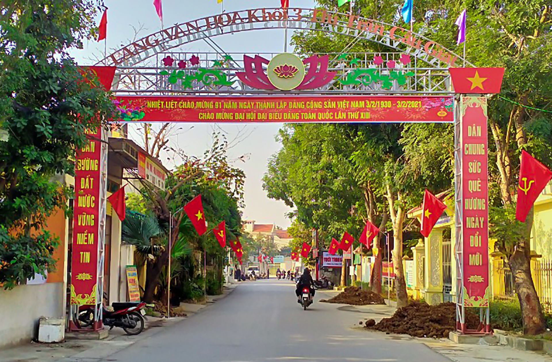 Cờ Đảng, cờ Tổ quốc đỏ rực tại một con ngõ ở khối 3, thị trấn Cầu Giát, huyện Quỳnh Lưu