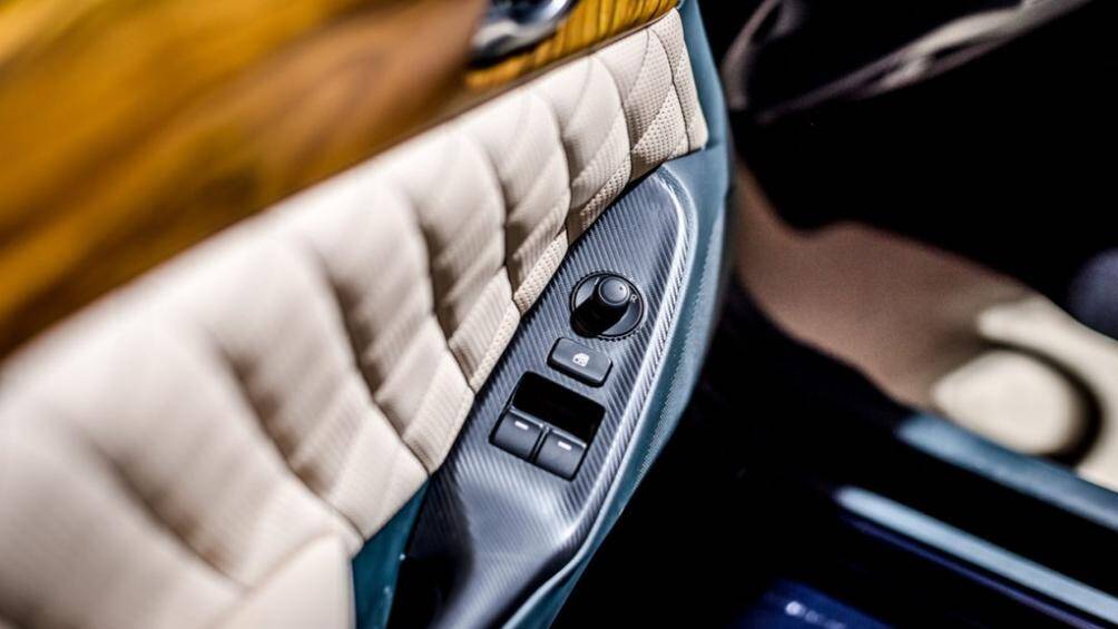 Viền cửa sổ và cụm nút chỉnh gương giả carbon. Hốc để đồ trung tâm khá giống với Mazda MX-5 ND