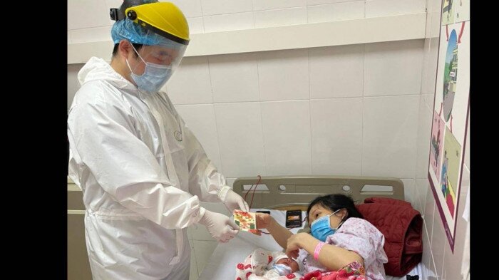 Bác sỹ Bệnh viện Sản Nhi mừng tuổi cho một bệnh nhân. Tết này, mọi y, bác sĩ ai cũng phải xa nhà, nhưng họ đều dốc lòng điều trị và chăm lo Tết chu đáo cho các bệnh nhân.