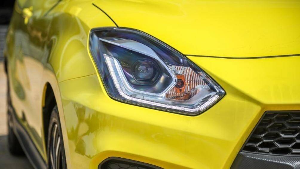 Ở giữa lưới tản nhiệt của Suzuki Swift Sport 2021 còn có thanh nằm ngang dày dặn với thiết kế giả sợi carbon thay vì nẹp mạ crôm như bản thường