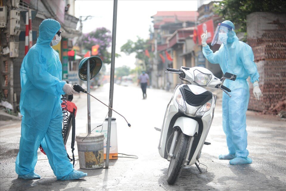 Lực lượng chức năng tiến hành sử dụng bình phun khử khuẩn các phương tiện ra vào, đảm bảo an toàn phòng dịch Covid-19.
