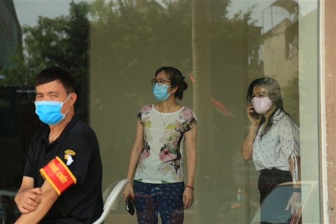 Nhiều người mang đồ ăn đến tiếp tế người th&acirc;n ở chung cư Đại Thanh bị phong toả.