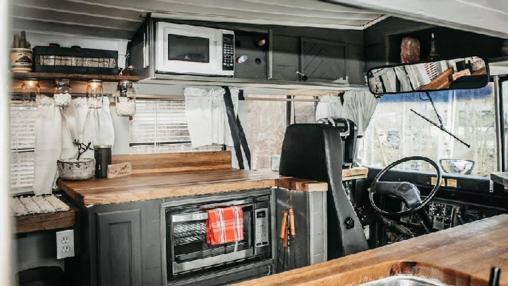 Tổng diện tích sử dụng vào khoảng 20 mét vuông, ngay phía sau ghế lái là khu vực nấu ăn với lò nướng, lò vi sóng, bồn rửa...