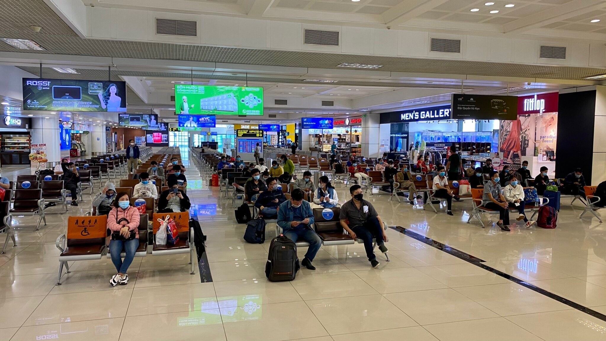Định kỳ hàng tuần tiến hành phun khử khuẩn luồng tuyến di chuyển của khách, quầy thủ tục, lối đi kiểm soát an ninh, cửa ra tàu bay, cầu ống lồng; toàn bộ khu vực nội địa đến/ nội địa đi; Tăng cường vệ sinh toàn bộ các bề mặt tiếp xúc mà hành khách thường chạm đến tại các khu vực của nhà ga hành khách. Trong ảnh, ghế ngồi trong phòng chờ ra tàu bay được dán decal giãn cách