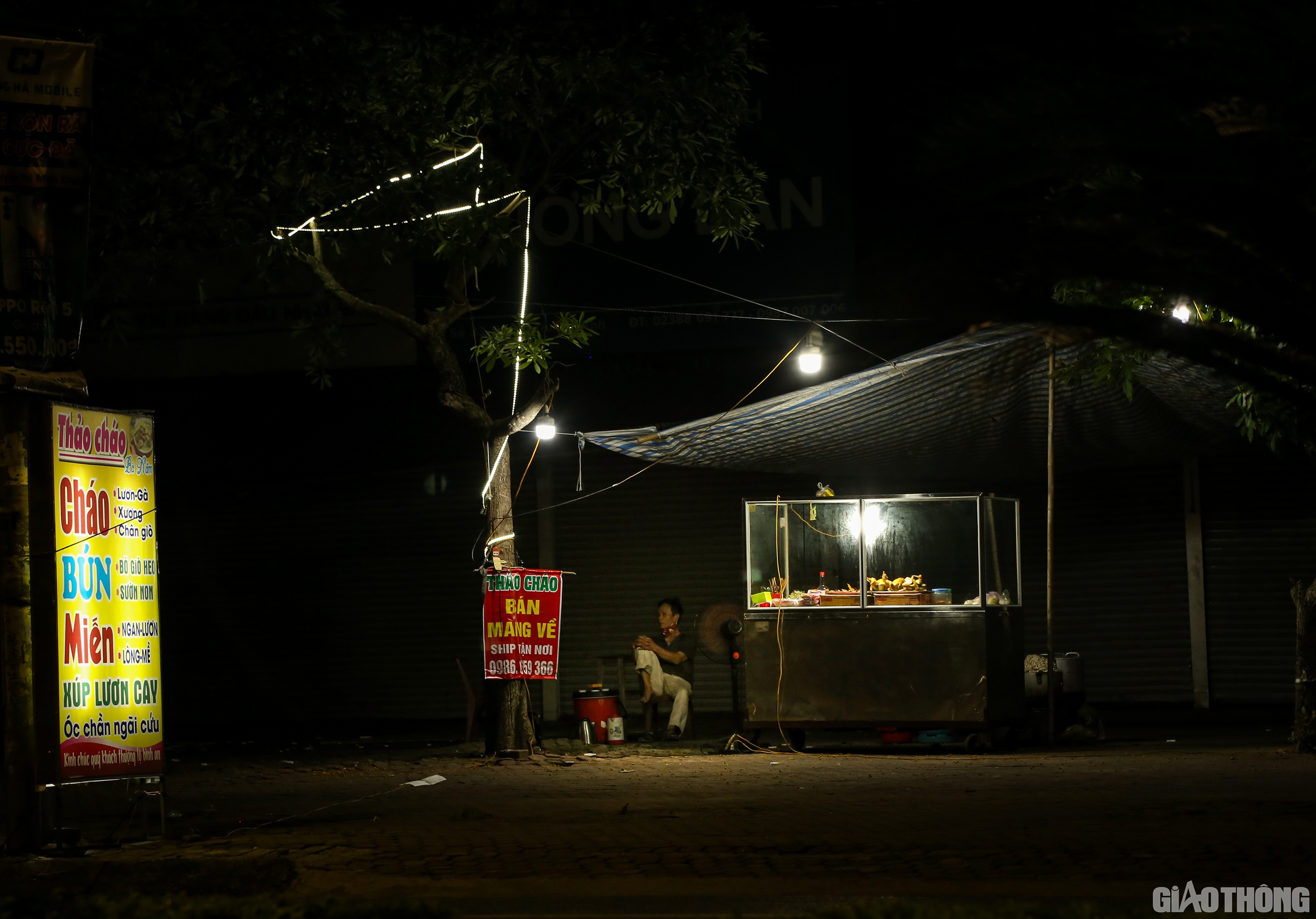Một quán ăn đêm trên đường Quang Trung cũng treo biển bán mang về, nhưng đường vắng không người, chủ quán ngồi dài trên ghế.