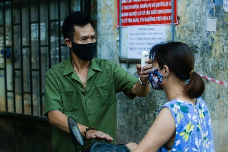Khi đến chợ, mọi người dân sẽ được đo nhiệt độ và nhắc nhở đeo khẩu trang, giữ khoảng cách an toàn.