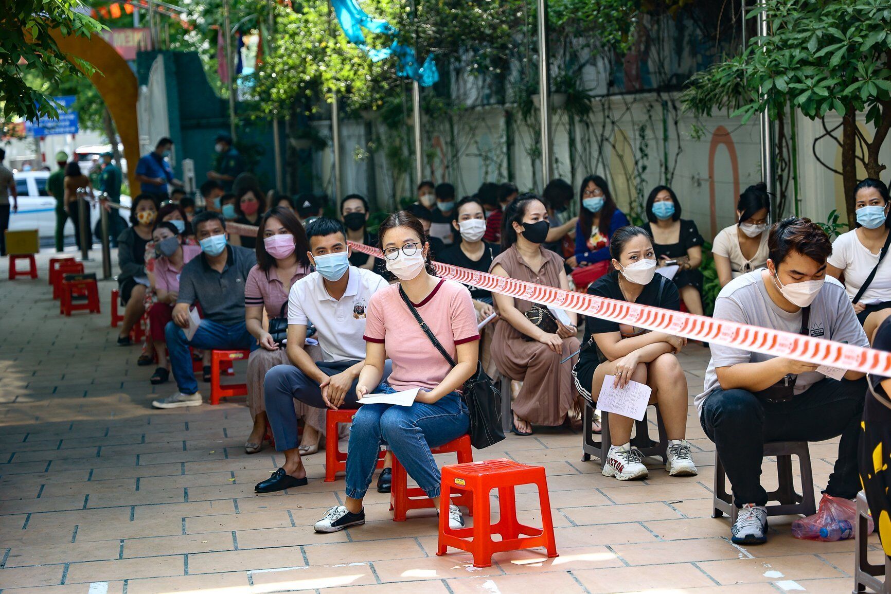 Sau khi nhận số thứ tự tiêm, người dân phải xếp hành chờ đến lượt, việc xếp hàng cũng phải tuân thủ nghiêm ngặt theo quy định phòng chống dịch Covid-19.