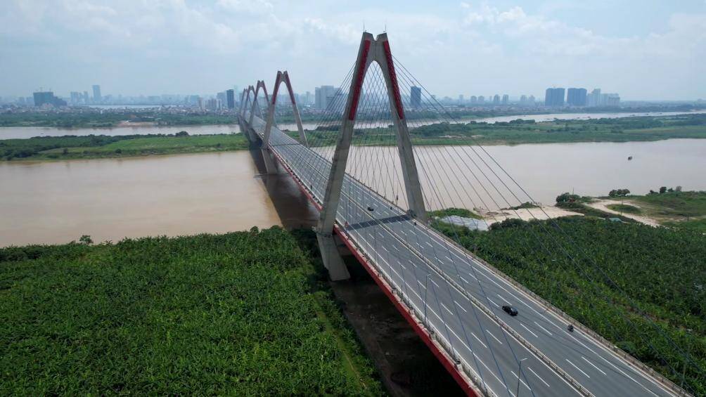 Cầu Nhật T&acirc;n, phải đứng kh&aacute; l&acirc;u mới thấy b&oacute;ng d&aacute;ng của những chiếc xe m&aacute;y, chiếc &ocirc; t&ocirc; đi qua.