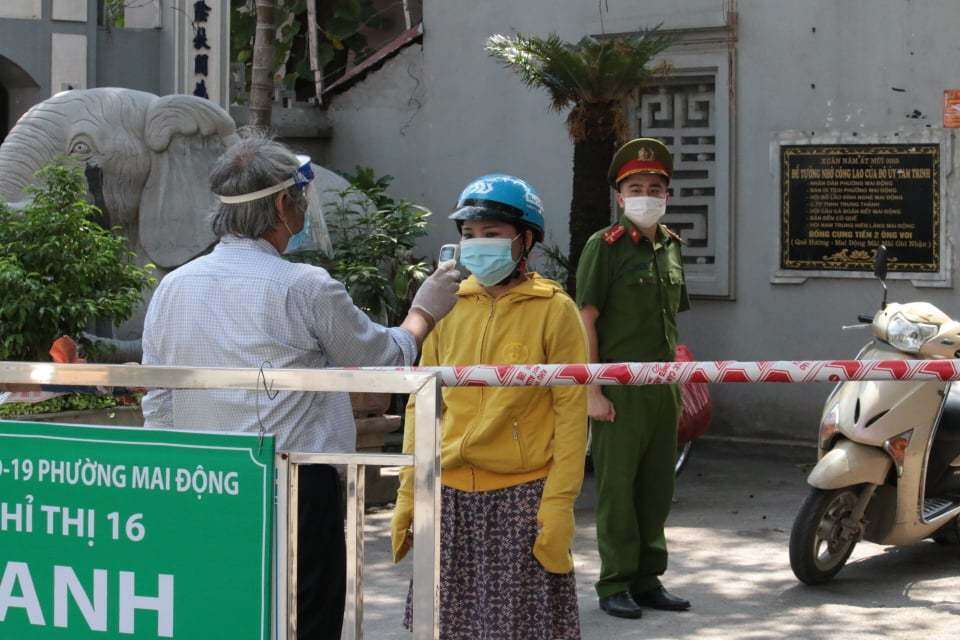 Người dân đều đồng lòng, vui vẻ, tự nguyện thực hiện các nội quy, bảo ban nhau nhằm bảo vệ "vùng xanh an toàn" của khu dân cư mình sinh sống. Ảnh chụp người dân đo nhiệt độ để ra/vào "vùng xanh an toàn" ở khu dân cư 1, phường Mai Động sáng 3/8.