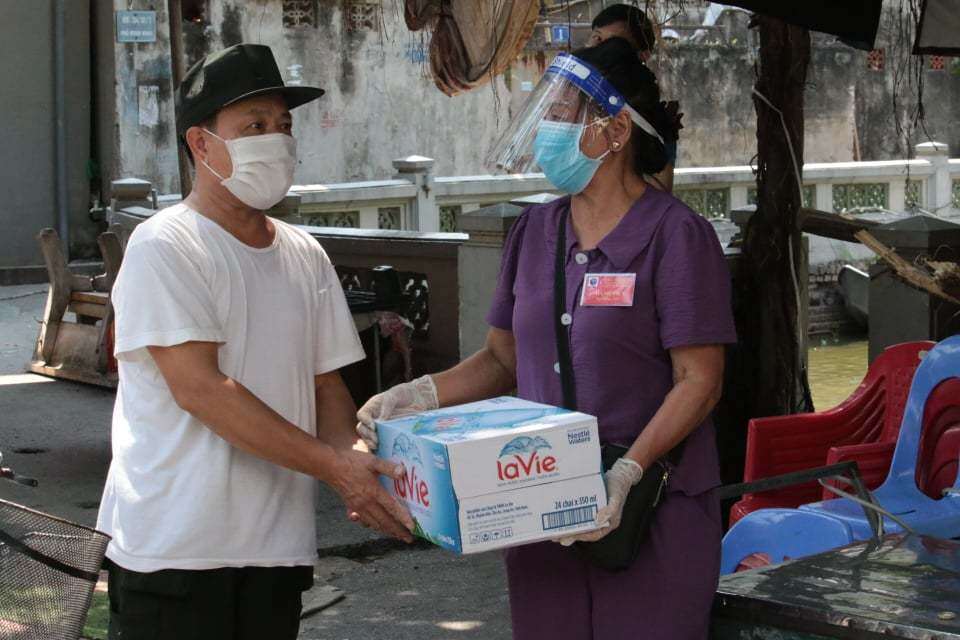 Lập chốt "vùng xanh an toàn", người dân rất ủng hộ. Những người lớn tuổi, có cả những bạn trẻ sẵn sàng tham gia trực chốt. Ảnh chụp người dân tặng nước uống cho chốt kiểm soát "vùng xanh an toàn" ở khu dân cư số 1, phường Mai Động.