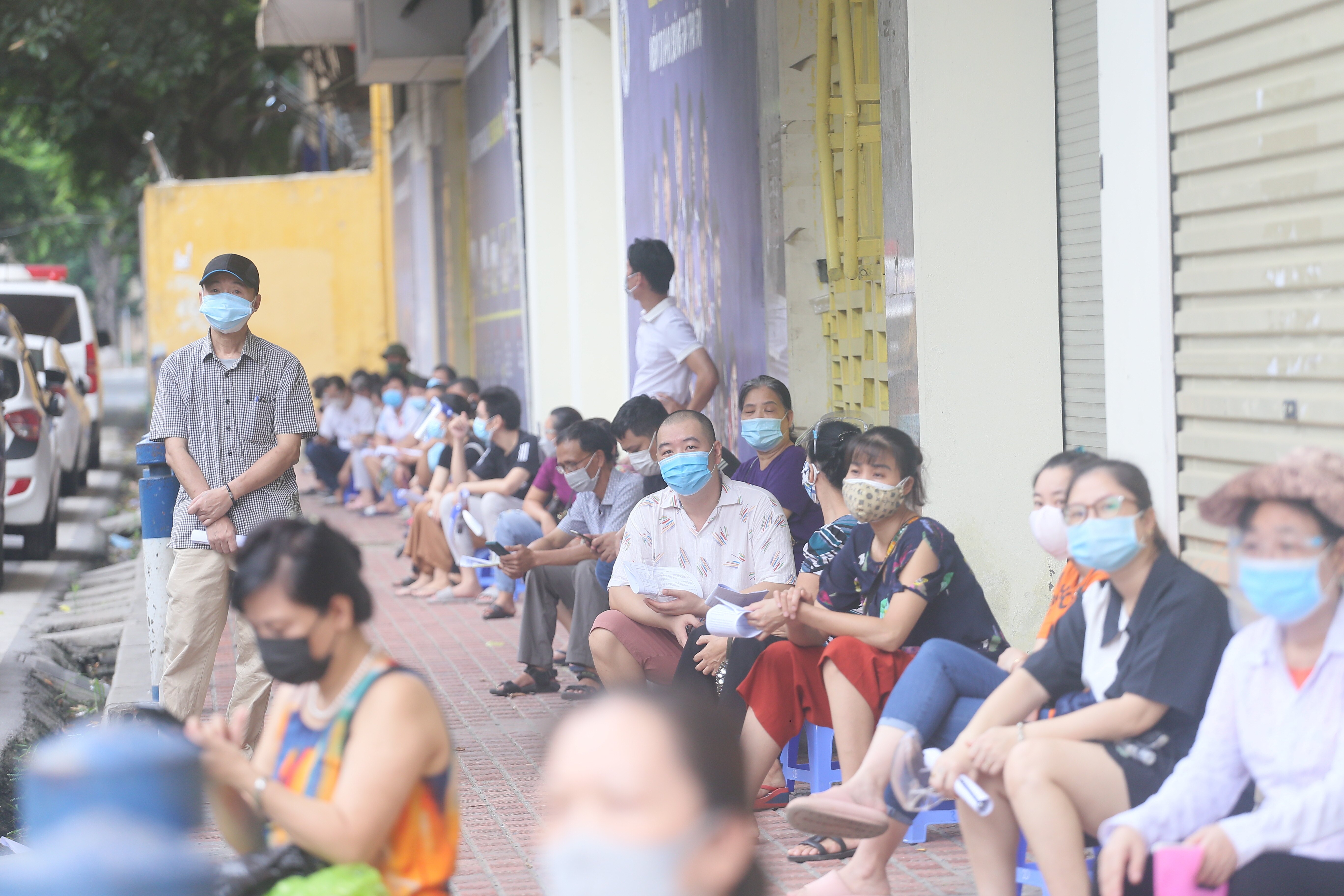 Trước khi đến lượt làm thủ tục tiêm vaccine, người dân đến đây được hướng dẫn xếp hàng giãn cách theo đúng quy định phòng chống dịch.