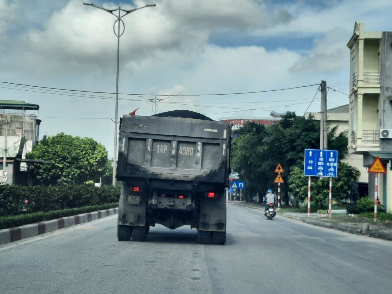 Một chiếc xe tải chở hàng cao vượt quá thành thùng, lại không che bạt chạy qua địa bàn Tp Uông Bí.