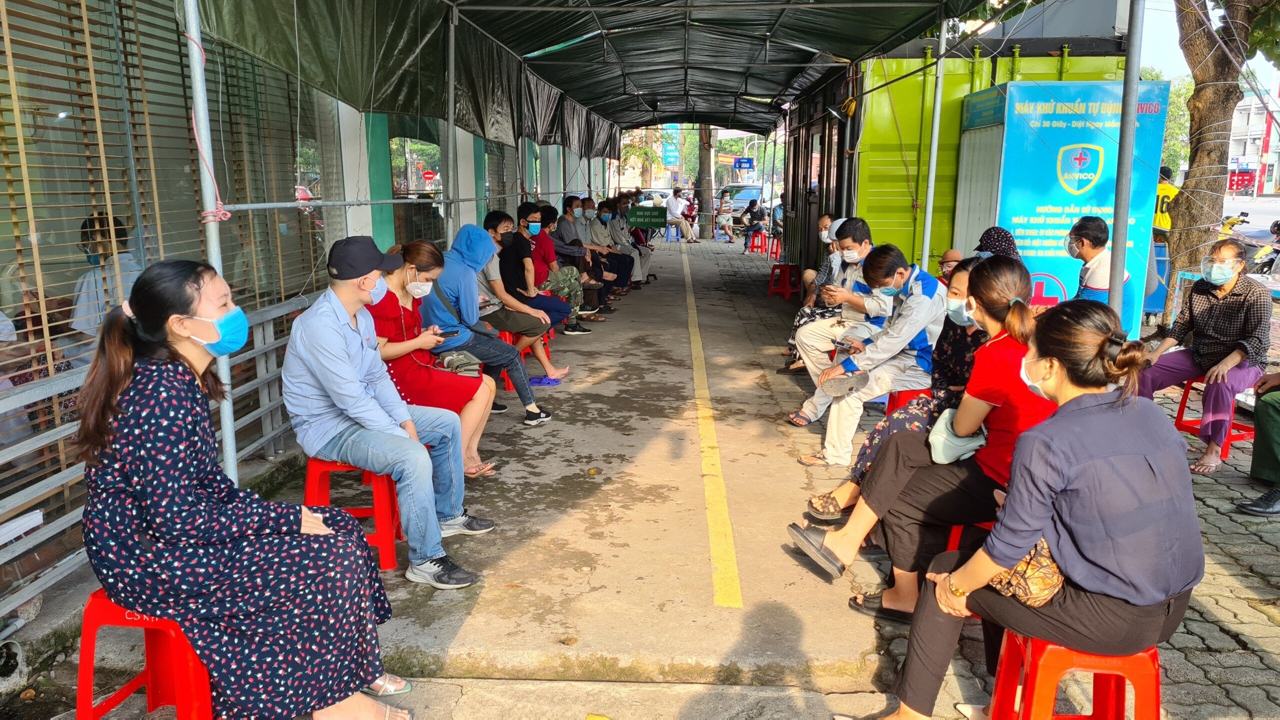 Chị Mai ngồi xếp hàng chờ hơn 1 tiếng nhưng vẫn chưa tới lượt. Chị Mai cho biết: em xem văn bản trên Facebook, thấy quy định người đi làm phải xét nghiệm 3 - 7 ngày/ lần nên cứ đi test cho chắc chắn, không lỡ bị phạt thì khổ