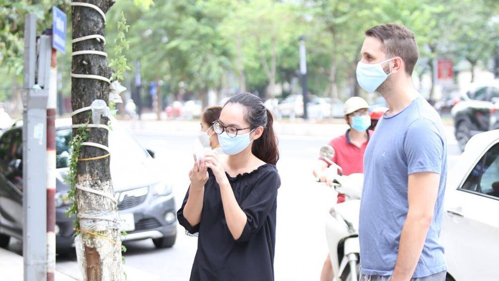 Người đàn ông ngoại quốc xếp hàng chờ mua phở trên đường Văn Cao cho hay, anh mua về cho cả vợ ở nhà cùng ăn: "Ăn phở ở quán thì ngon hơn, nhưng dịch bệnh nên mua về nhà ăn cũng tốt rồi".