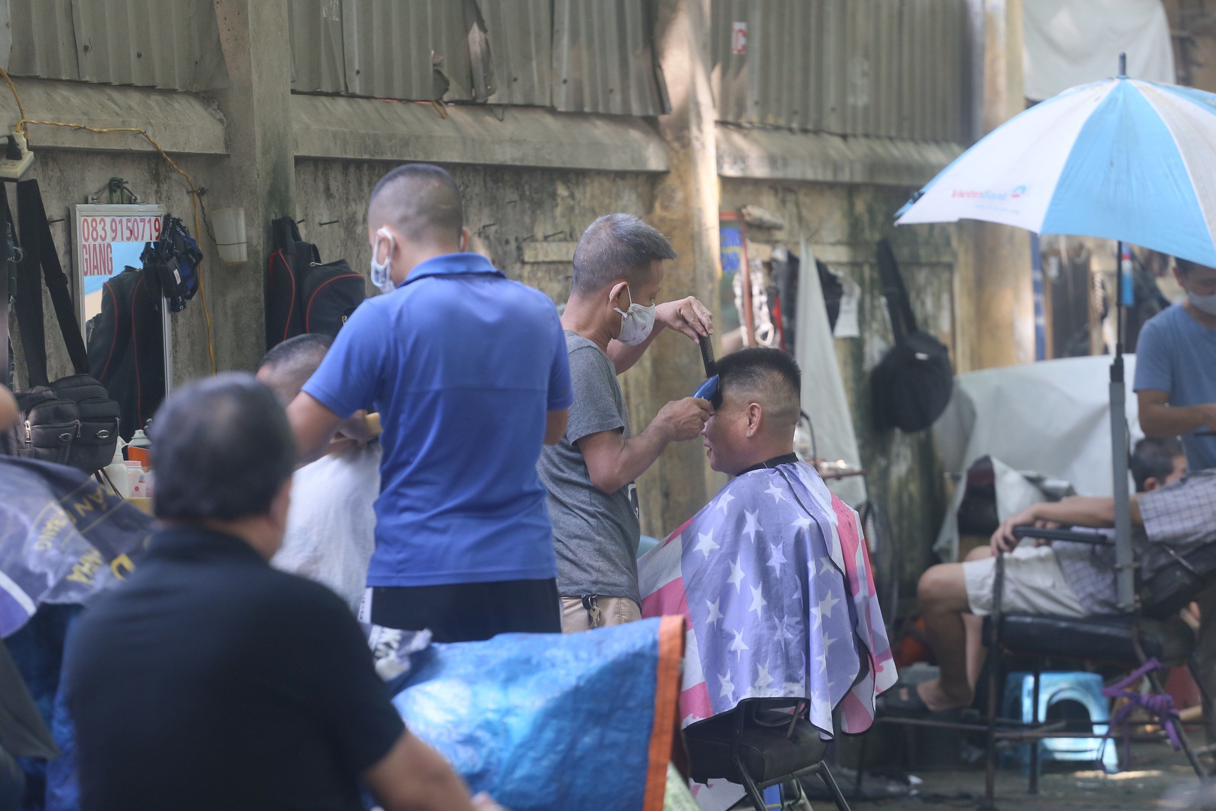 Hàng loạt "salon tóc" vỉa hè phố Thái Thịnh cũng hoạt động hết công suất từ 6h sáng.