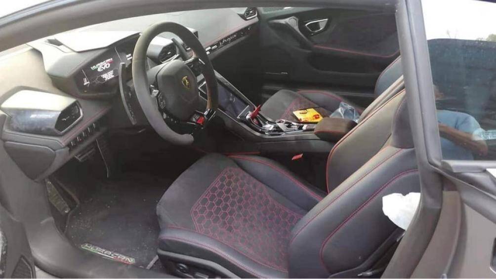 Ghế ngồi của xe bọc da màu tối mà sọc đỏ nổi bật bao gồm chỉ thêu