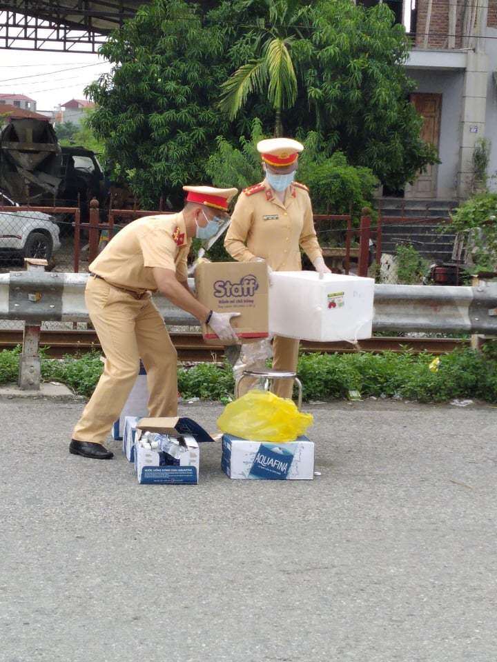Lực lượng CSGT tất bật chuẩn bị đồ ăn, nước uống cho bà con các tỉnh phía Nam đi xe máy về quê qua Hà Nội.