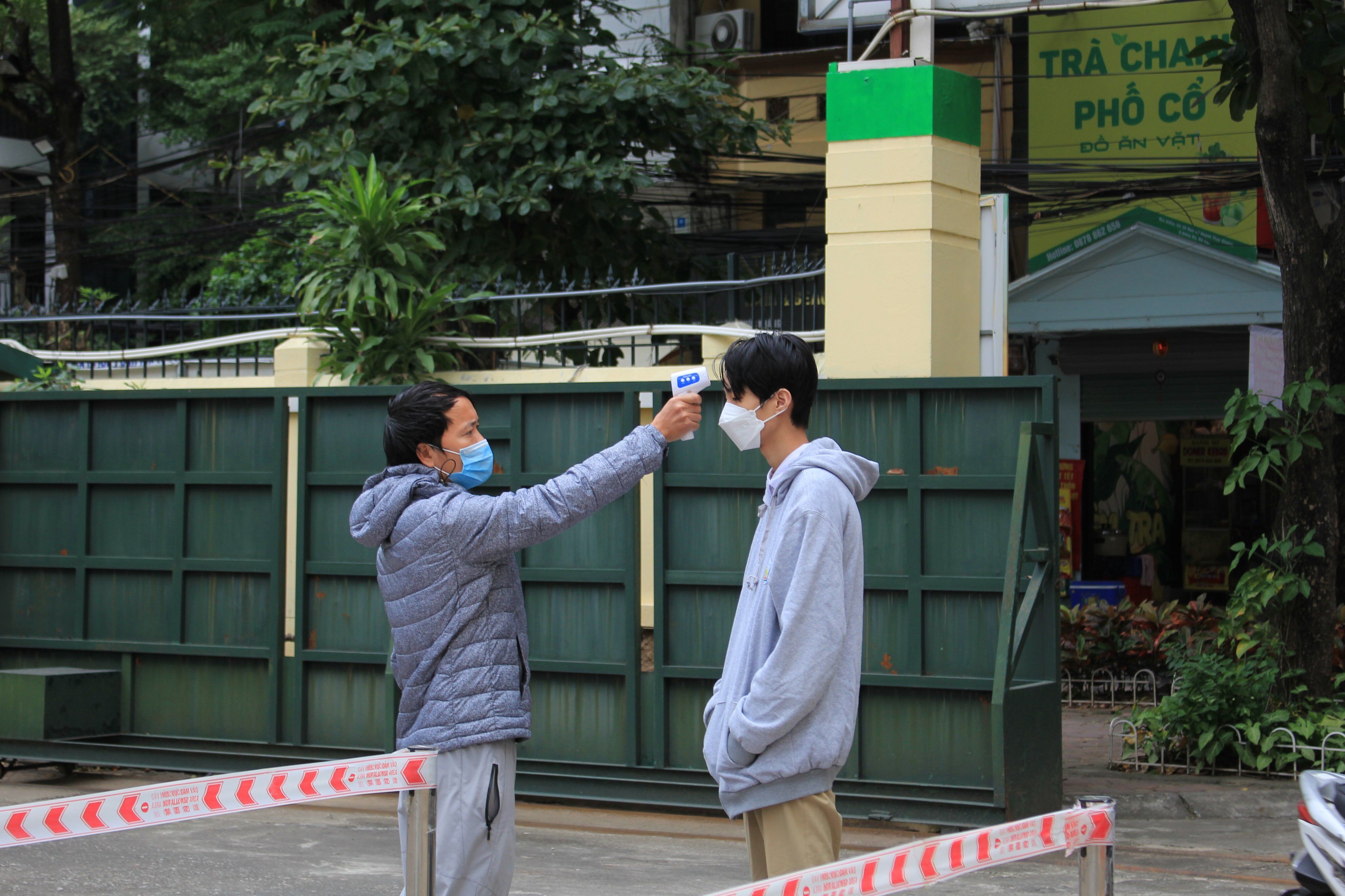 Trước khi vào trường các em học sinh được đo thân nhiệt và yêu cầu sát khuẩn tay và đeo khẩu trang đầy đủ.