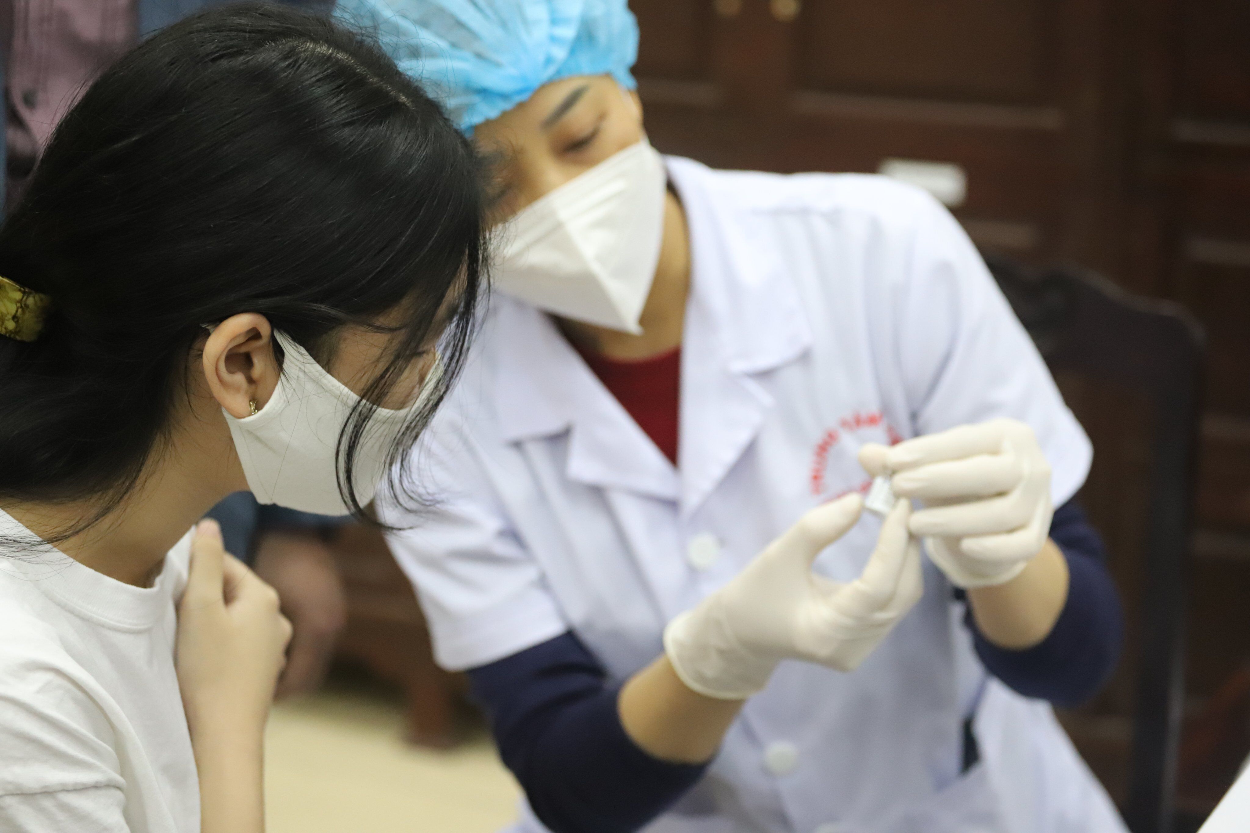 Nhân viên y tế đọc rõ loại vaccine để các em học sinh biết trước khi chính thức tiêm.