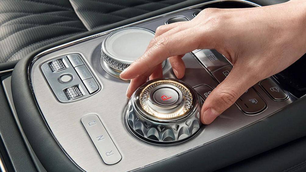 Giữa xe, ngang với bệ tỳ tay là cụm cần số và núm điều chỉnh chế độ lái cao cấp màu bạc