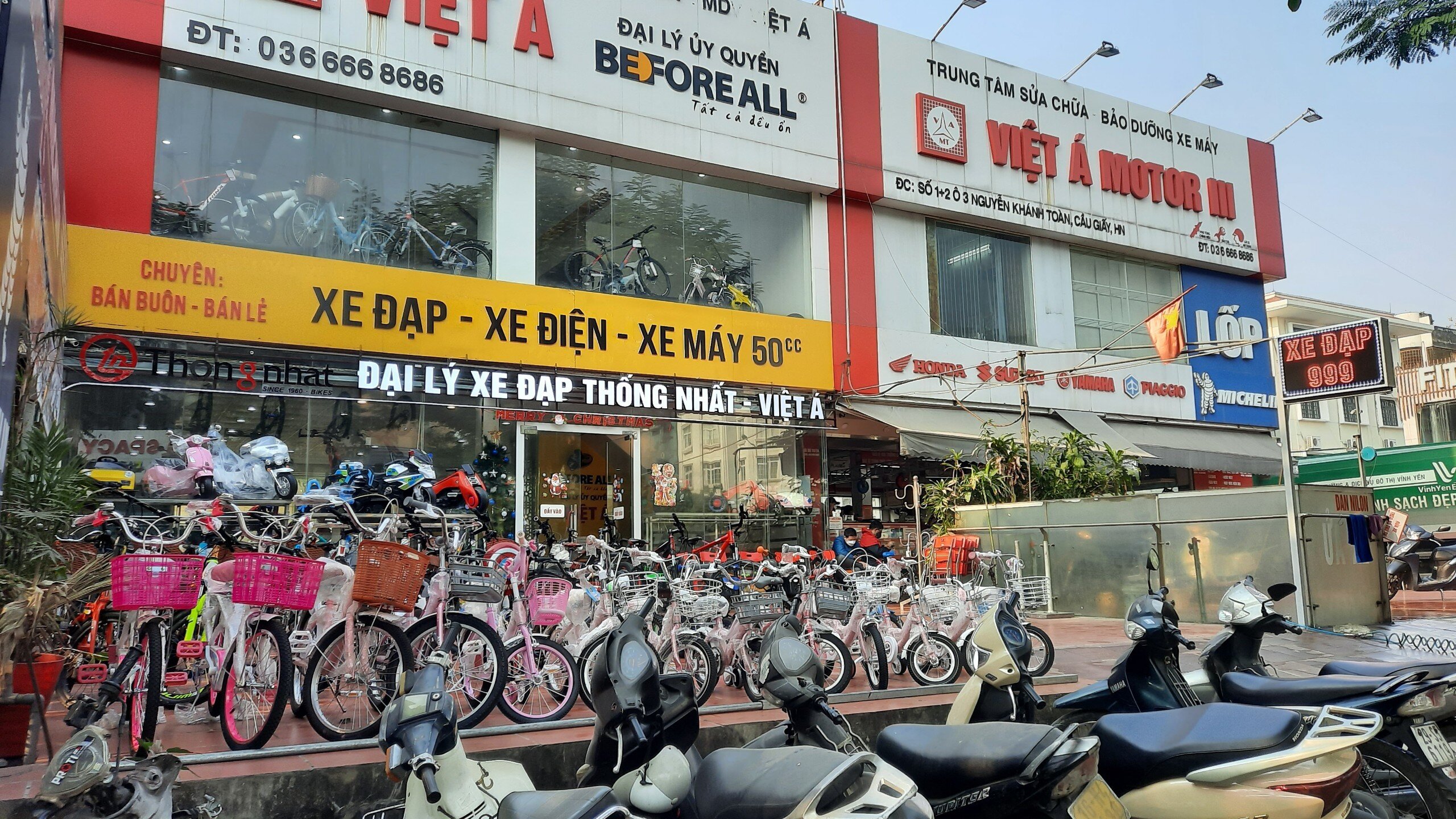 Nhiều quán cà phê, cửa hàng mua bán, sửa chữa ô tô; cửa hàng mua bán sửa chữa xe máy; nơi trông giữ xe ô tô vẫn hoạt động tấp nập tại khu đất này. Trong ảnh là Công ty TNHH Đầu tư phát triển thương mại dịch vụ Việt Á vẫn đang hoạt động buôn bán và sửa chữa xe đạp, xe điện, xe máy điện.