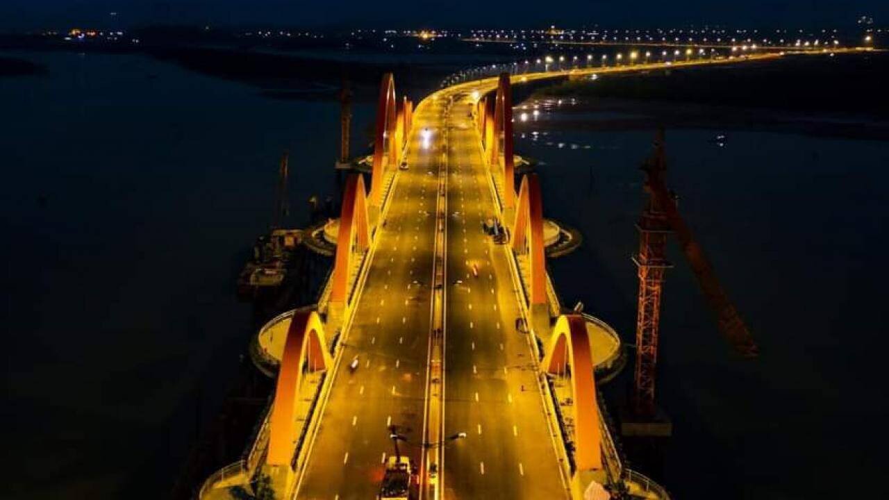 Cầu Tình Yêu chính được thiết kế dạng vòm ống thép nhồi bê tông với 6 làn xe cơ giới, tổng mức đầu tư của công trình là 2.109 tỷ đồng. Ảnh: Đêm đến, cầu Tình Yên như chú rồng khổng lồ đang hạ xuống vịnh Cửa Lục.