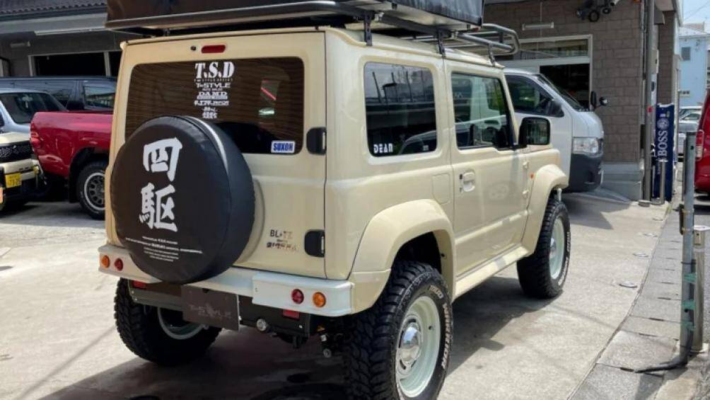 Ngoại thất chiếc Jimny được hoàn thiện bằng màu sơn kim loại trắng ngà Chiffon theo phong cách safari đặc trưng của Jimny