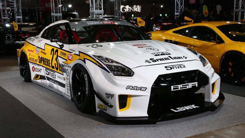 Bên cạnh đó là chiếc Nissan GT-R R35 LB-Silhouette Works được sơn màu trắng cùng họa tiết với các phần tem giống như một chiếc xe đua
