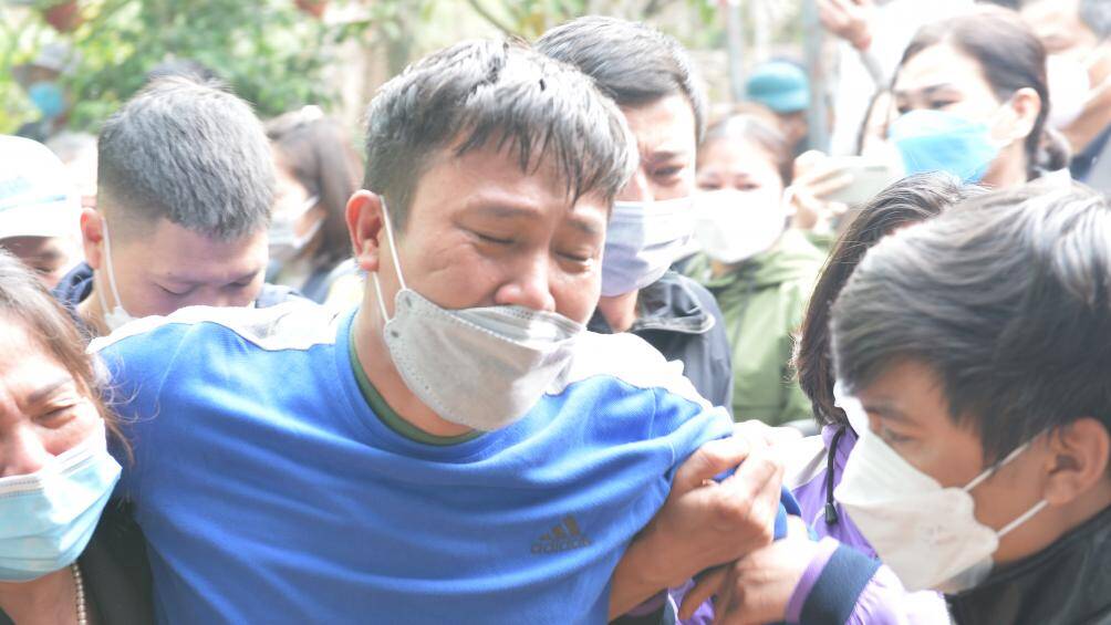 Anh Ngô Đức Đương, bố của hai cháu bé khóc lịm khi đưa con về đến quê nhà. Lúc này, một số người thân phải dìu anh Đương vào nhà