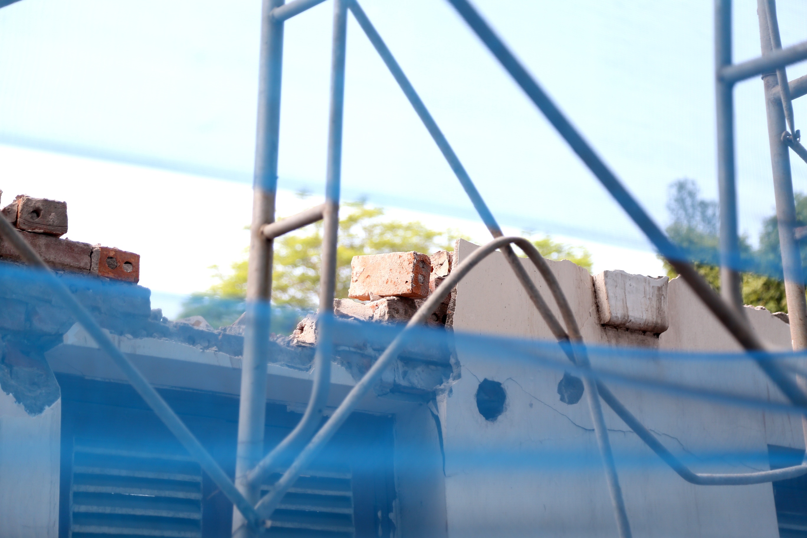 Những bức tường ngăn cách giữa đường và phía trong khu đất đang được phá dỡ dang dở.