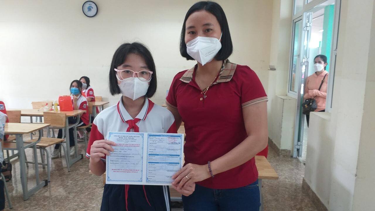 Cầm tờ chứng tiêm chủng mũi 1 cho con gái Nguyễn Tuệ Phương, học sinh lớp 6A2, chị Nguyễn Thị Thu Nga nhà ở khu 4, phường Hồng Hà, TP Hạ Long phấn khởi khoe: "Trong đợt dịch Covid -19 này, vợ, chồng em lo nhất là các con nhỏ chưa được tiêm chủng. Nay cho con đi tiêm, thấy sức khỏe của cháu bình thường sau tiêm, em mừng lắm. Phụ huynh chúng em rất cảm ơn sự chăm lo cho trẻ em của các ngành, các cấp".
