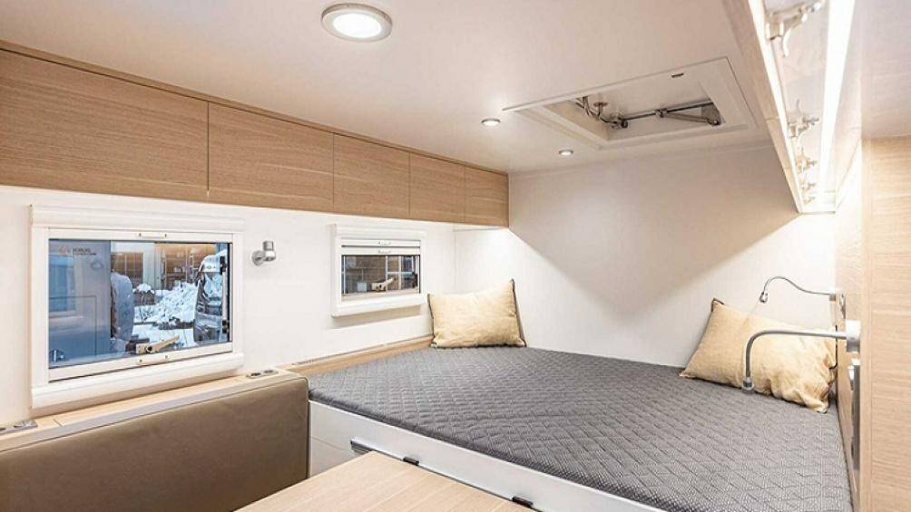 Bên trong có giường ngủ cỡ lớn, tủ quần áo, phòng tắm, khu bếp từ hiện đại có bồn rửa và bàn ăn dạng trượt