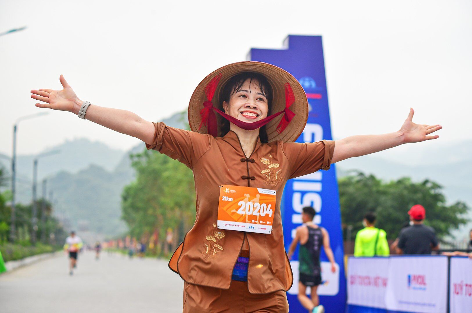 Một vận động viên tham gia cự ly 21km với chiếc nón lá đội trên đầu để lại nhiều ấn tượng cho các cổ động viên.