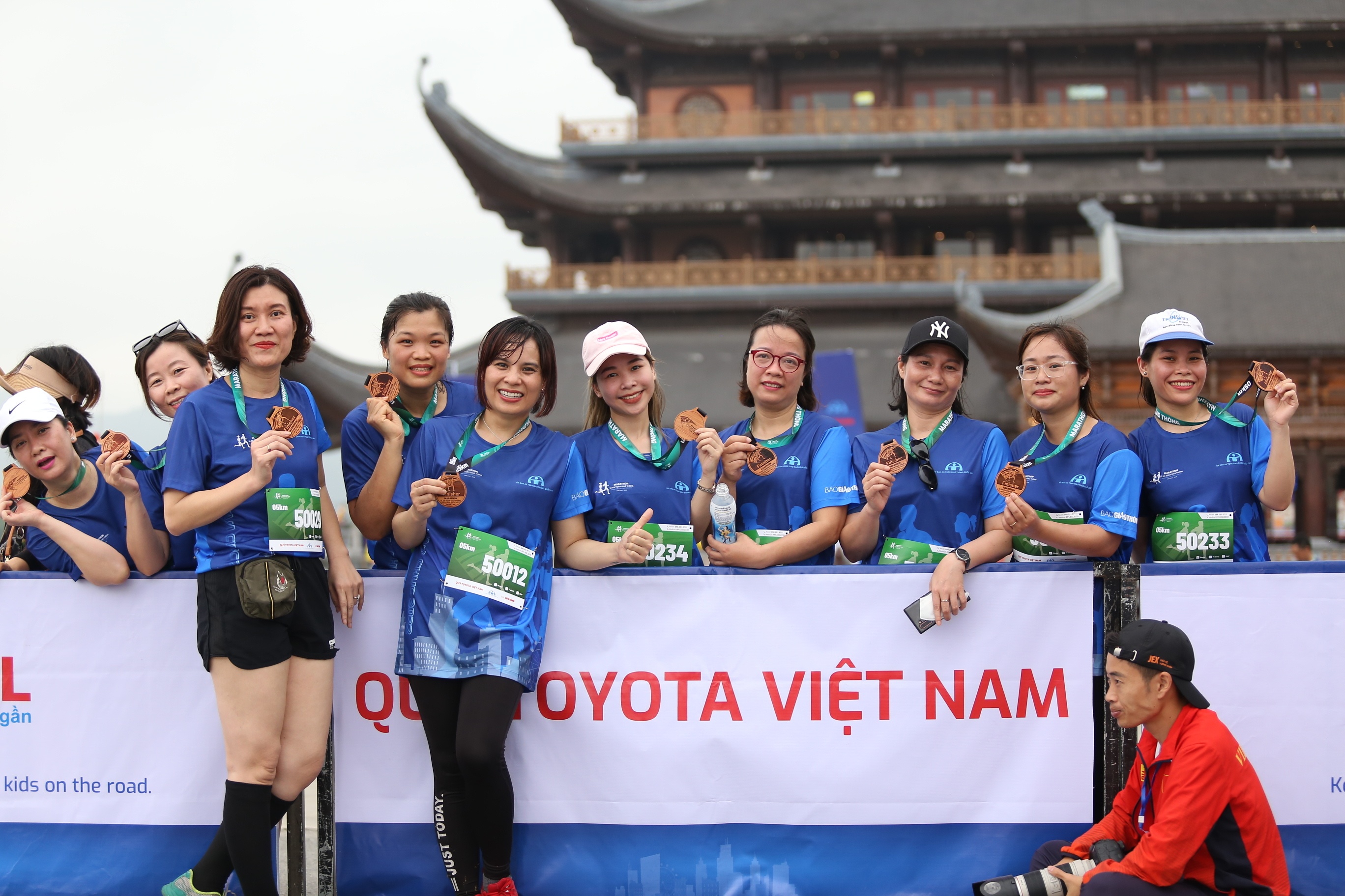 Các vận động viên chụp ảnh lưu niệm bên tấm huy chương vừa nhận được.