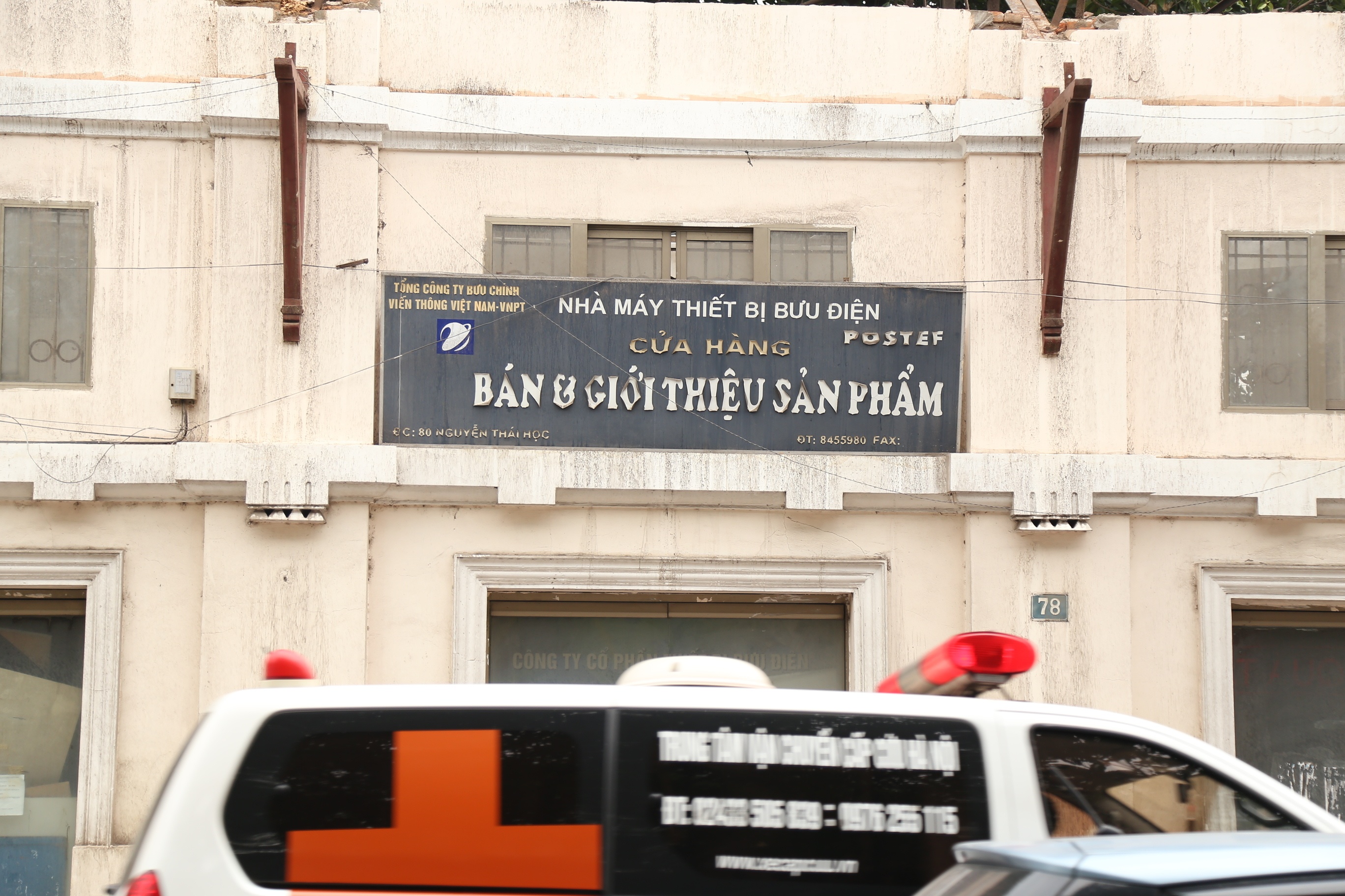 Bảng hiệu Nhà máy thiết bị Bưu điện (Postef) đã bị bạc màu và bị bong tróc.