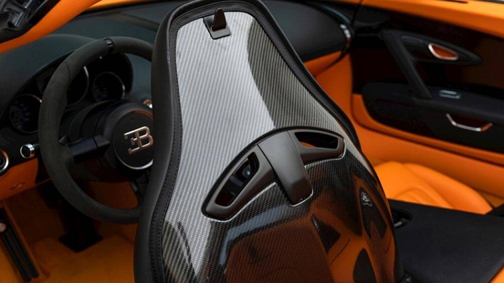 Bên trong, Bugatti Veyron Grand Sport Vitesse này có khoang cabin 2 tông màu, gồm màu da cam và đen sáng, kết hợp với nhiều chi tiết ốp sợi carbon tối màu độc đáo