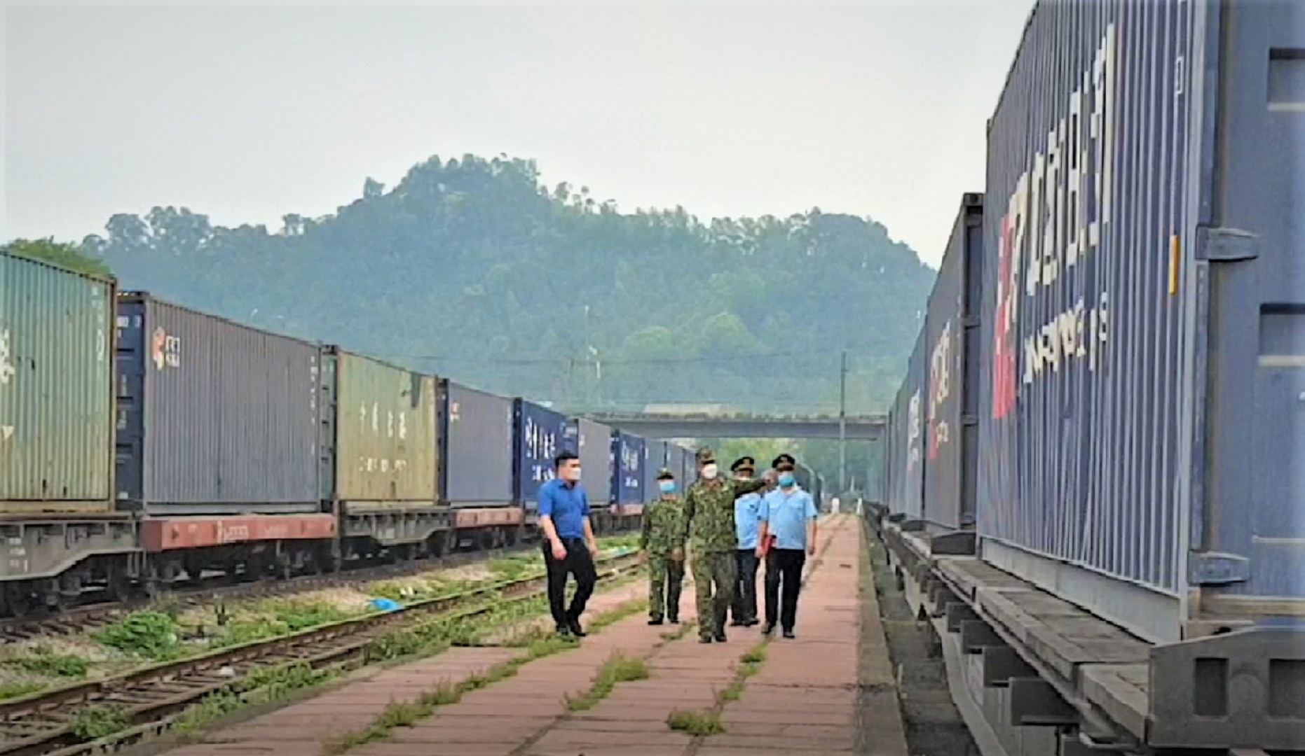 Hàng nhập chủ yếu: Hạt nhựa, giấy cuộn, gỗ ván ép, hàng công nghiệp, thực phẩm, sữa, hàng nông nghiệp, linh kiện điện tử… Hàng xuất chủ yếu đến Trung Quốc: Quặng sắt, hàng gỗ mỹ nghệ, giầy da, may mặc, thuốc bắc, gỗ ván bóc... Hàng hóa hai chiều đều phải đóng trong container hoặc toa xe khổ 1.435mm của đường sắt Trung Quốc.
Ảnh: Các lực lượng kiểm tra tàu liên vận.