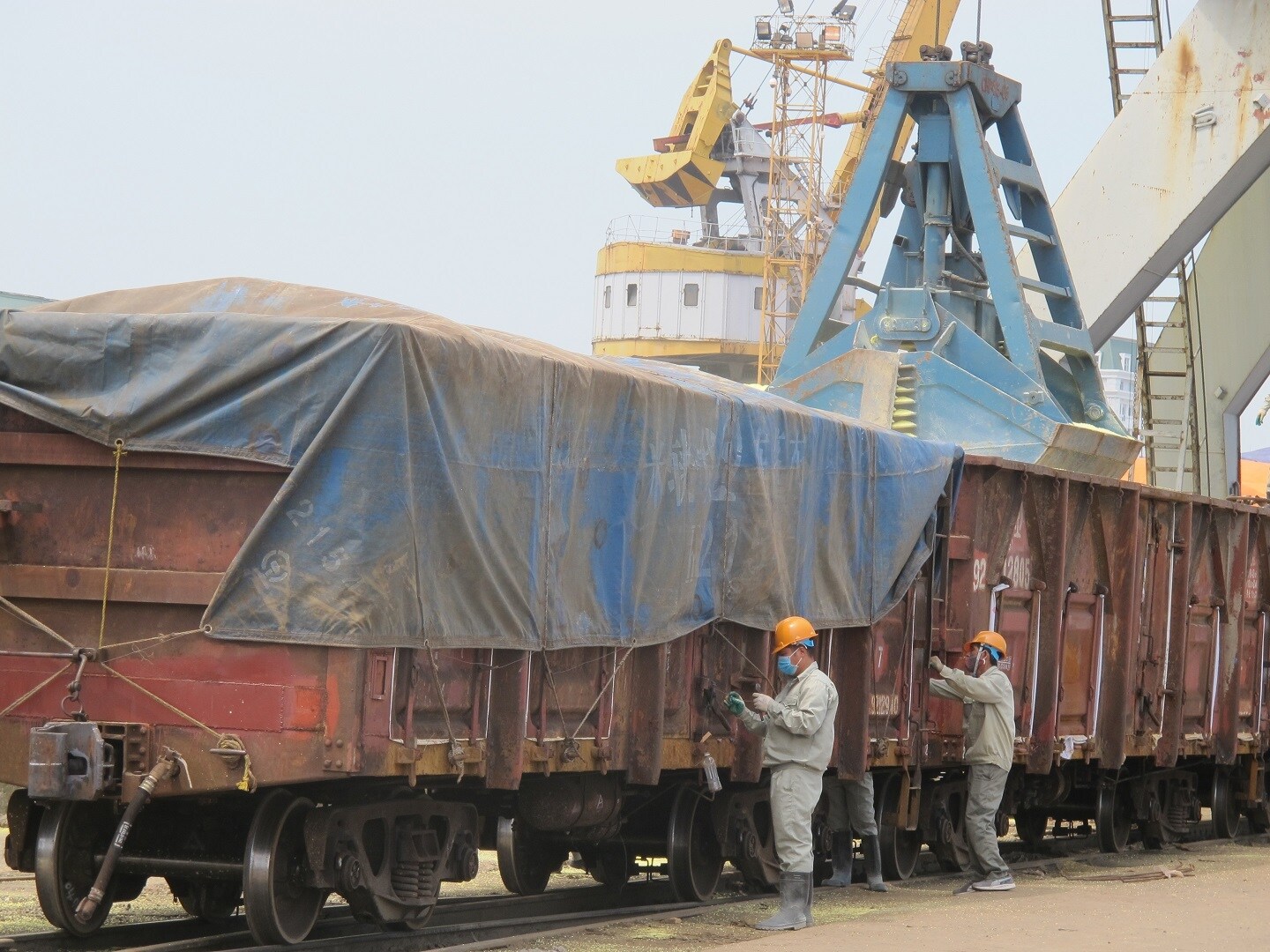 Toàn bộ hàng hóa tổ chức xếp dỡ, chuyển tải tại khu vực ga cảng và cầu cảng. Giám sát hải quan đối với phương tiện vận tải và làm thủ tục hải quan đối với hàng hóa xuất nhập khẩu. Hàng hóa sau khi được xếp lên toa xe sẽ được phủ bạt, niêm phong, làm thủ tục hải quan và chạy thẳng ga Lào Cai. Tại ga Lào Cai sẽ chỉ làm thủ tục thông quan, không phải kiểm hóa, toa xe giữ nguyên niêm phong được kéo sang ga Sơn Yêu. 
Ảnh: Công nhân phủ bạt, gia cố, niêm phong toa xe hàng sau khi xếp tại cảng Hải Phòng