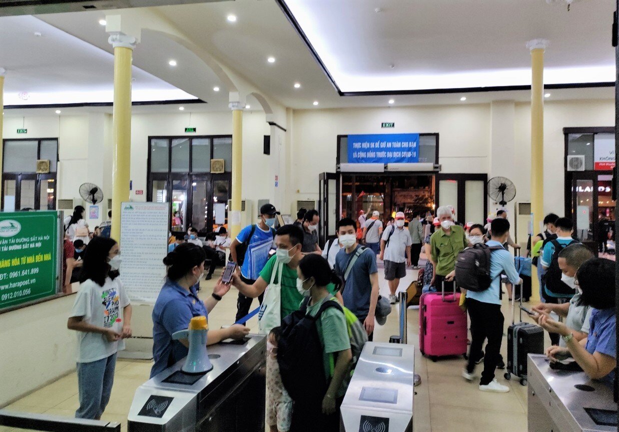 Tuy nhiều chuyến nhưng do giãn cách giữa các chuyến xa, nhà ga mở nhiều cửa đón khách, nhiều phòng đợi tàu nên không bị ùn ứ. Ảnh: Nhân viên kiểm soát vé hành khách trước khi vào ga.