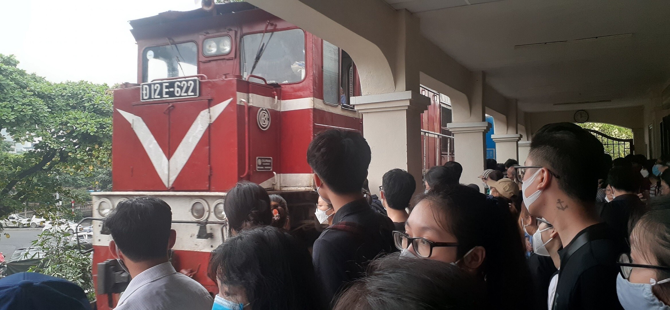 Nhiều hành khách ra cả hành lang phòng đợi ga Long Biên, chờ tàu đến.