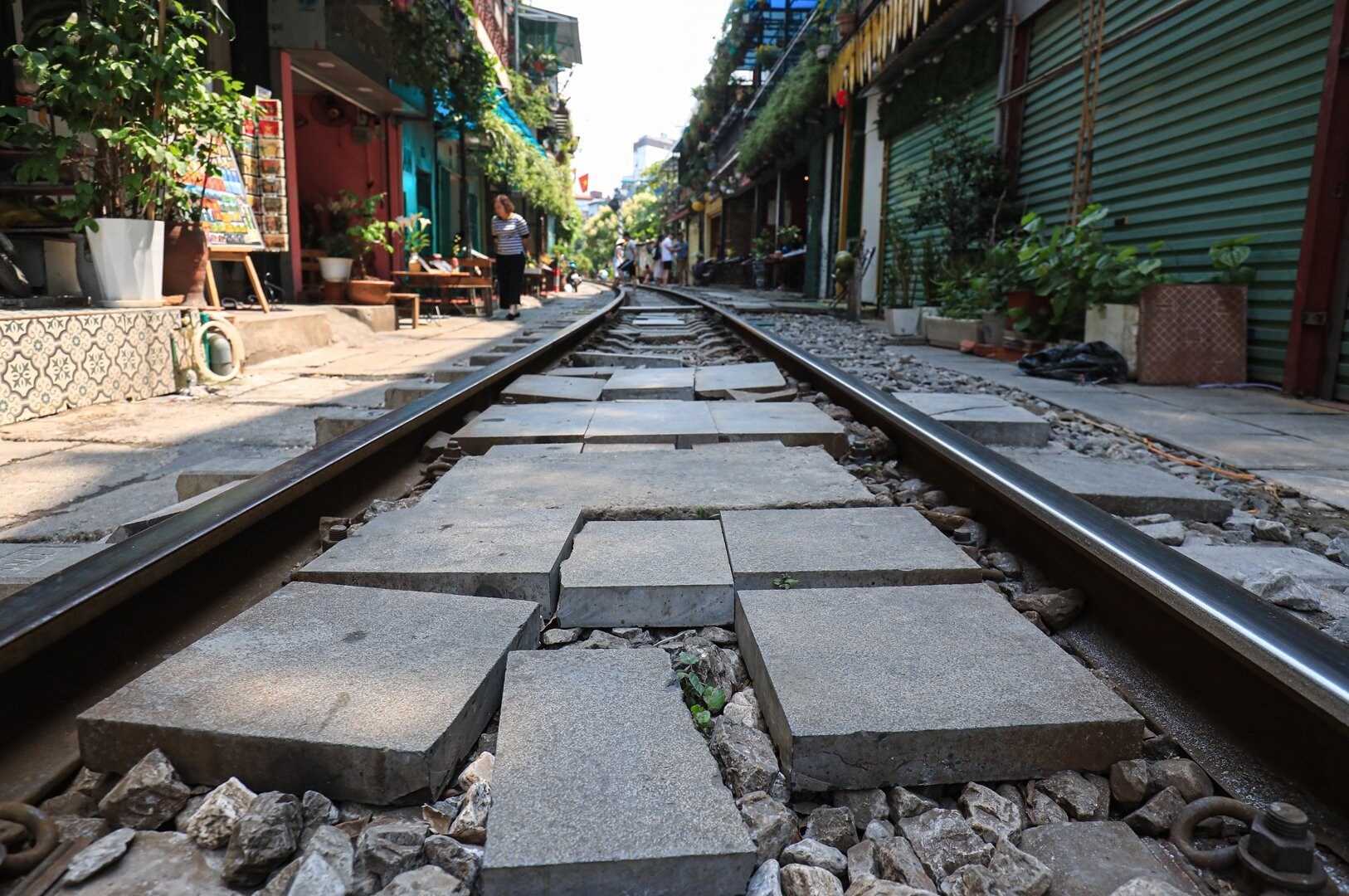 Việc bán hàng quán, người đi lại đông đúc trên đường sắt càng tiềm ẩn nguy cơ tai nạn. Vị này cho biết, sáng 30/4 vừa qua, đoàn tàu LP3 xuất phát ga Hà Nội đi Hải Phòng khi đến khu vực đã phải dừng lại do quá đông khách đứng chụp ảnh, nguy cơ tàu va quệt. Hơn nữa, các hàng quán tự ý kê lót các vật liệu làm lối đi qua đường tàu, khi tàu qua dễ xảy ra trật bánh nếu bánh tàu va phải. Ảnh: các tấm đan để trong lòng đường sắt, nguy cơ mất an toàn chạy tàu cao