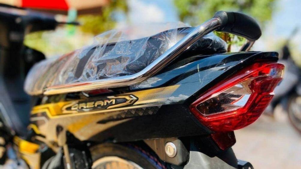 Biểu tượng Honda Dream ở đầu xe được sơn màu ѵàng đồng tạo điểm nhấn. Tem xe mới với sự kết hợp giữa 2 màu chủ đạo là ѵàng ѵà bạch kim