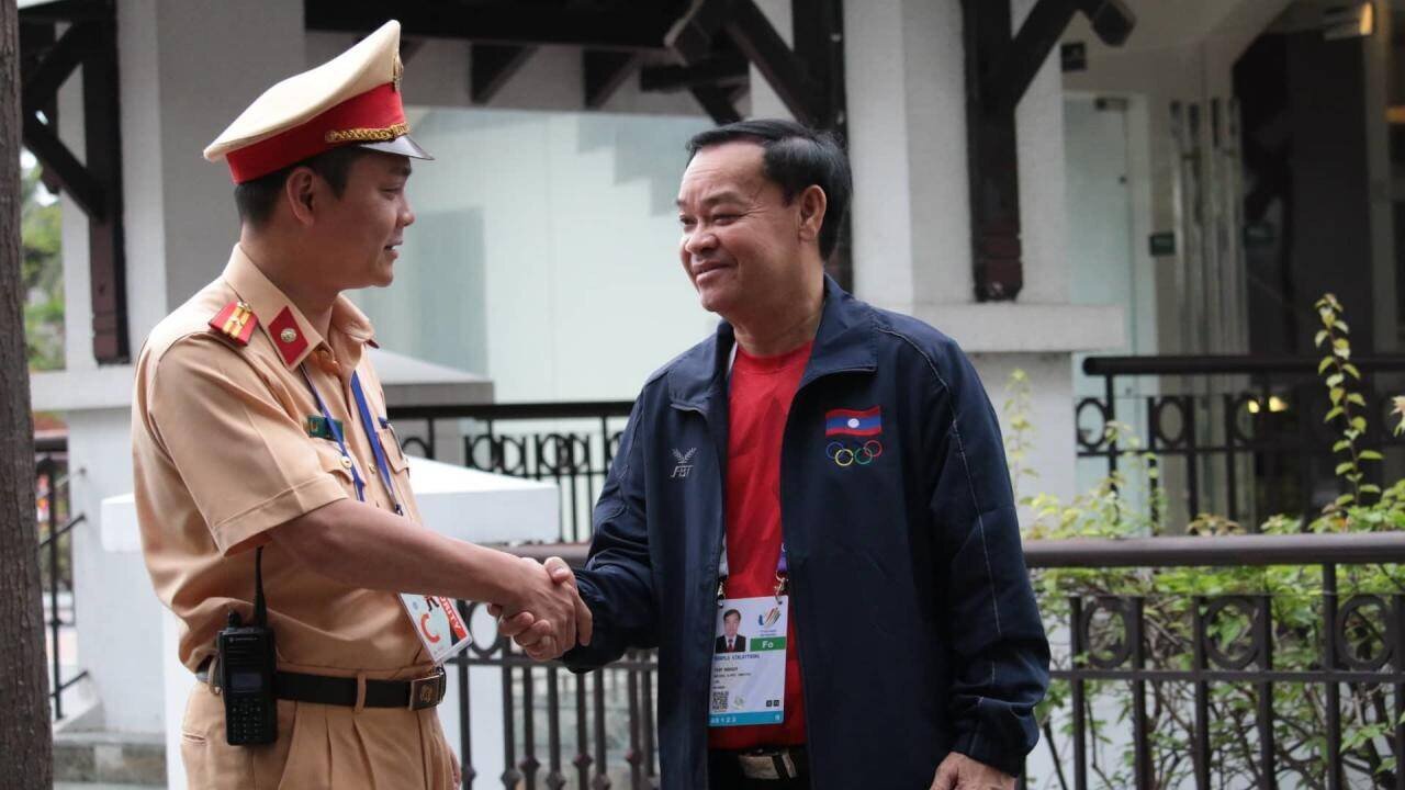 Cán bộ CSGT Hà Nội chào hỏi, bắt tay với đại diện đoàn thể thao nước bạn Lào trước khi mời đoàn lên xe, xuất phát từ khách sạn đến nơi thi đấu.