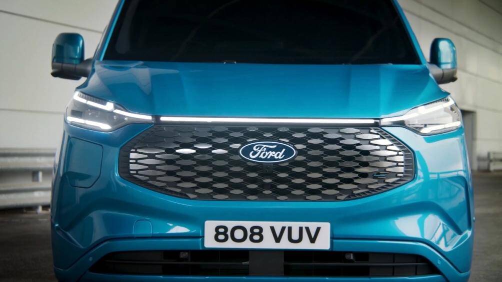 Ford E-Transit Custom 2024 có phần mũi xe đáng chú ý với lưới tản nhiệt đính đá, ngay trên là thanh đèn kết nối cụm đèn pha 2 bên khá lạ mắt