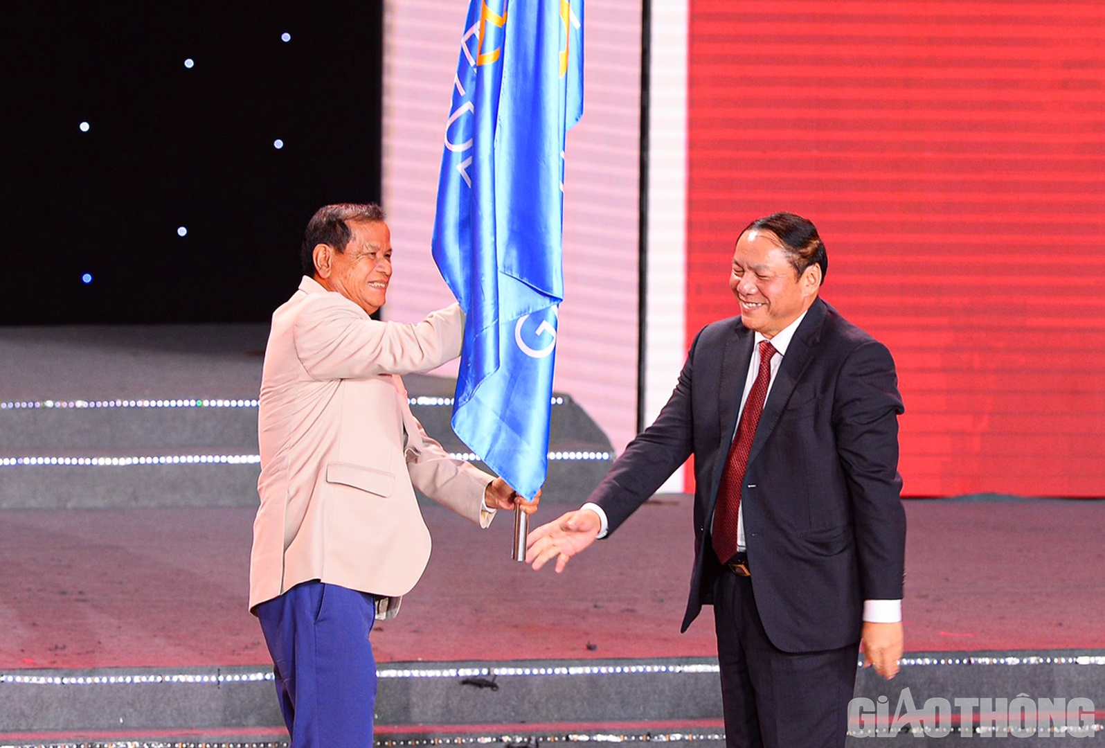 Bộ trưởng Bộ Văn hóa Thể thao và Du lịch Nguyễn Văn Hùng trao cờ Liên đoàn thể thao Đông Nam Á từ chủ nhà Việt Nam cho đại diện Ủy ban Olympic Campuchia - nước chủ nhà SEA Games 32.