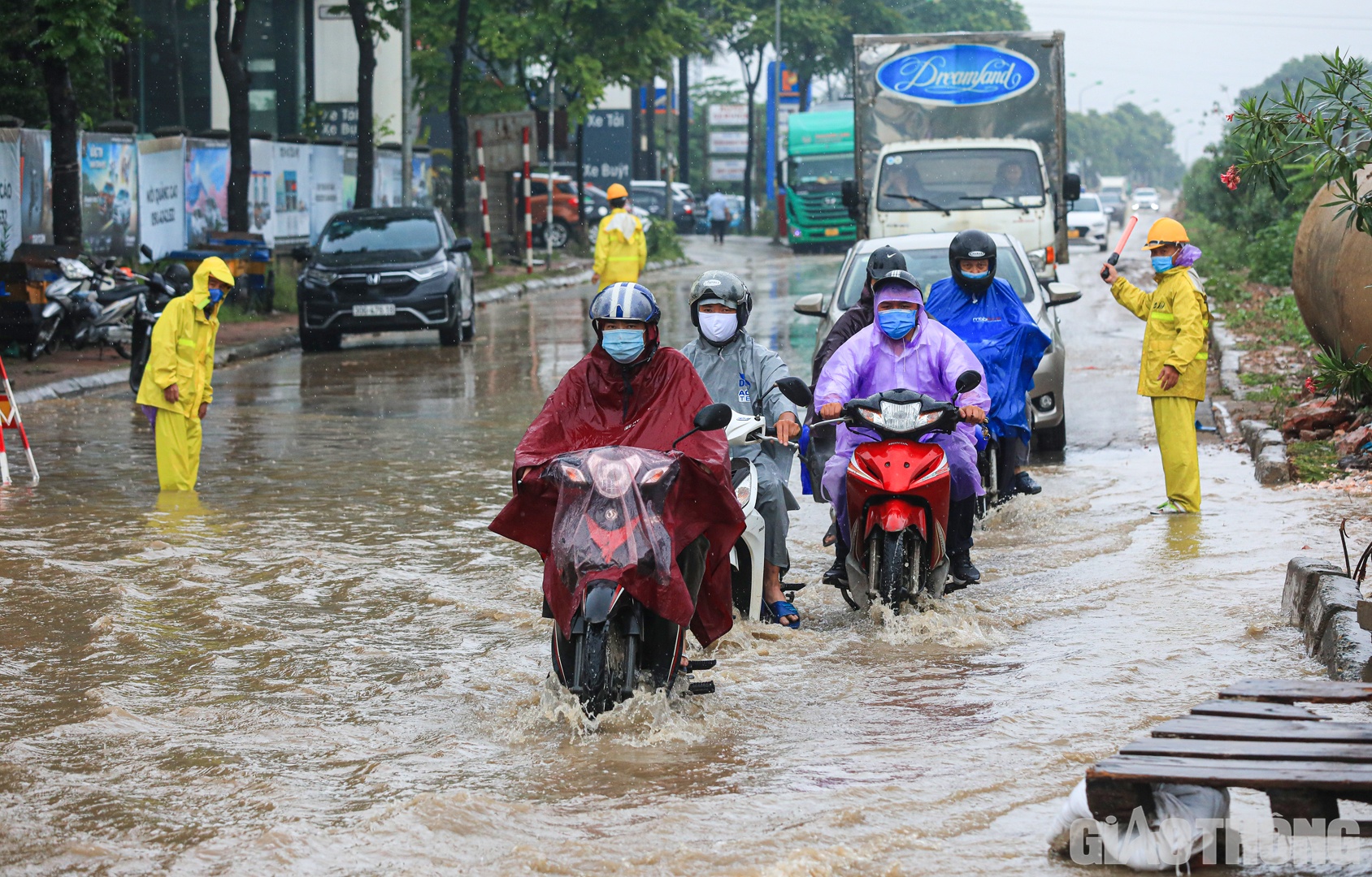 Các nhân viên công ty thoát nước túc trực, hỗ trợ người dân đi qua điểm ngập nước.